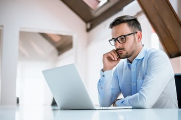 homem de camisa azul mexendo no notebook